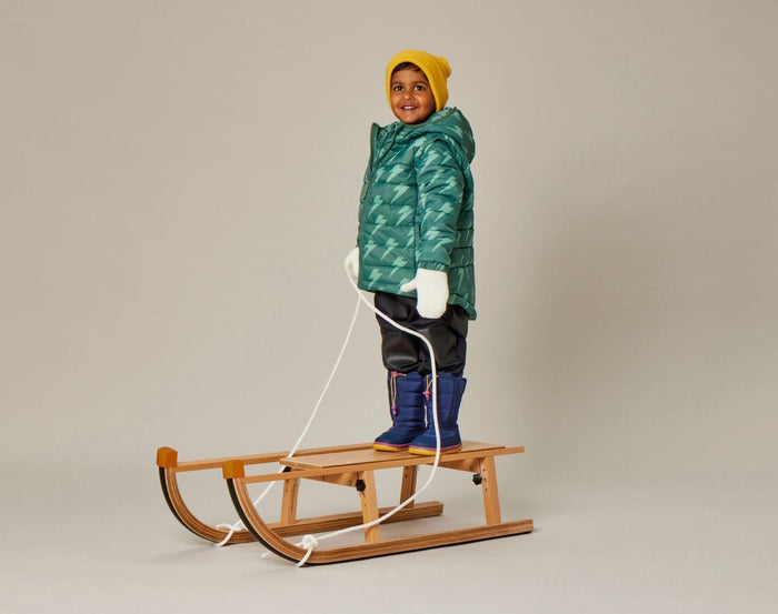Child on sled wearing Snapper Rock - 2 in 1 Puffer Jacket & Vest - Lightning Bolt - Available at www.tenlittle.com