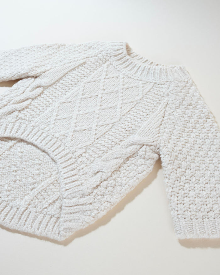 Soft ivory cable knit dog sweater, perfect for chilly weather and trendy pups.