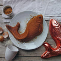 gateau en forme de poisson dans une grande assiette en porcelaine blanche de forme irrégulière - tsé tsé