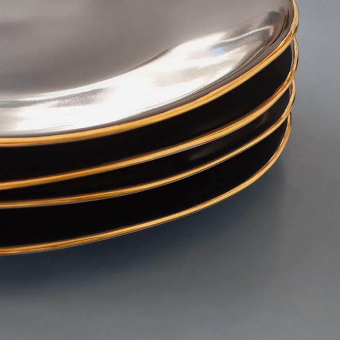 détail d'une pile d'assiettes noires avec rebords or