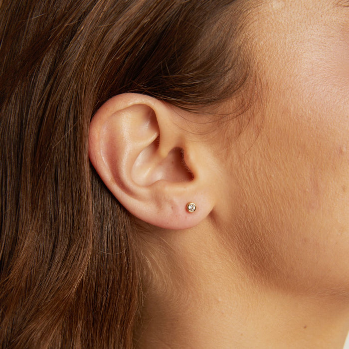 Model. Close-up of an ear with a small earring