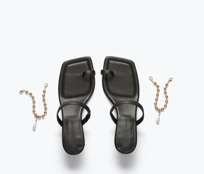 Black FREDA SALVADOR Aurora heel sandal with calf chain strap and open toe design.