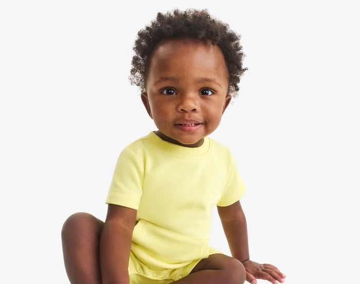 Baby sitting wearing Primary Baby French Terry Romper - Buttercup. Available at www.tenlittle.com