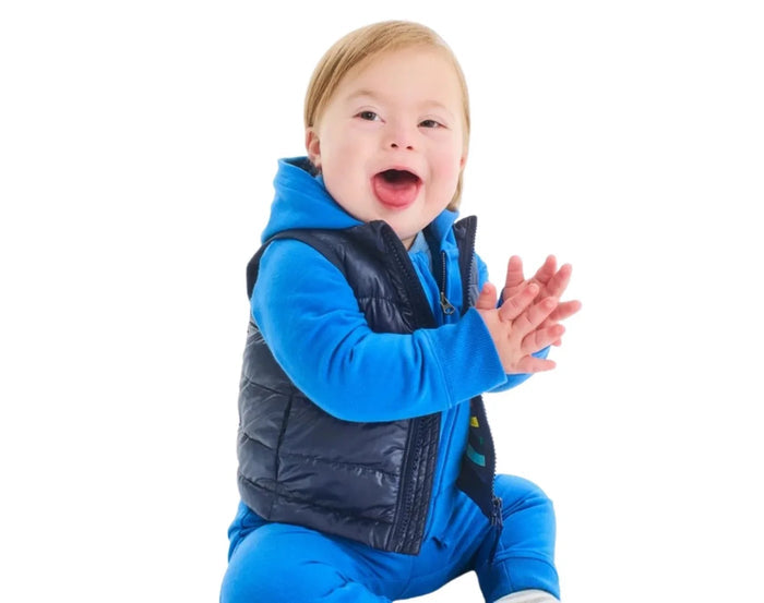 Baby sitting wearing Primary Baby Lightweight Puffer Vest - Navy. Available at www.tenlittle.com