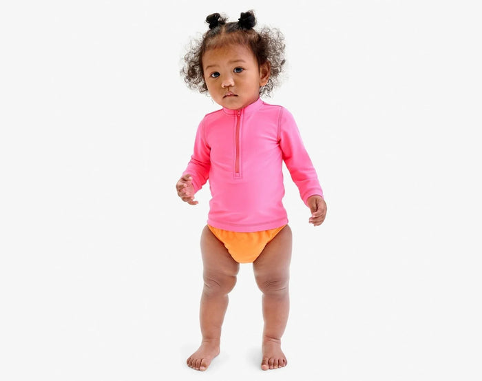 Baby wearing Primary Swim Diaper - Cantaloupe. Available at www.tenlittle.com