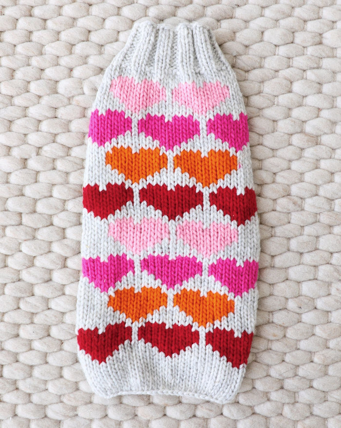 Red knit dog sweater with white heart pattern for Valentine's Day.