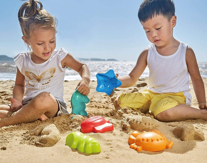 Kids playing with Hape Beach Toy Essential Set on the beach