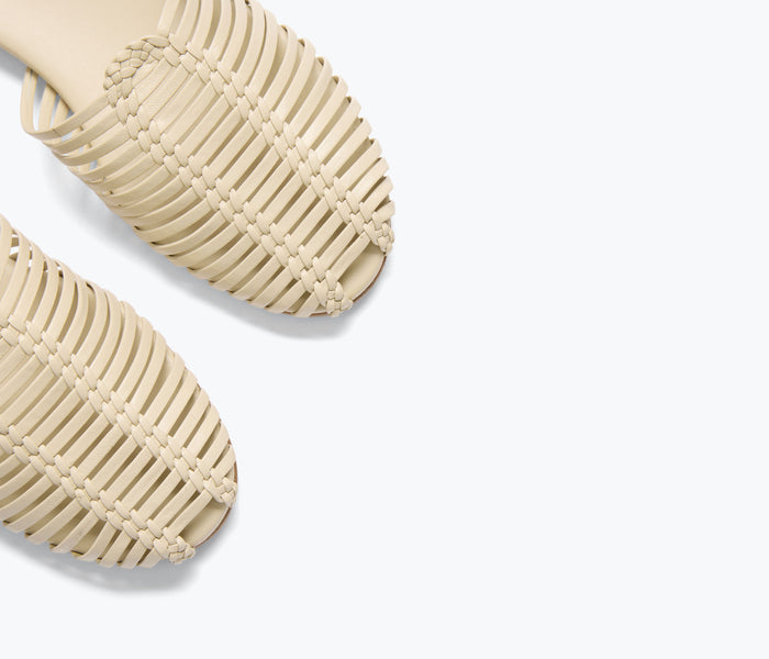 Freda Salvador Blake Caged Woven Flat shoe in vanilla color, showing detailed woven strap design on the flat footwear.