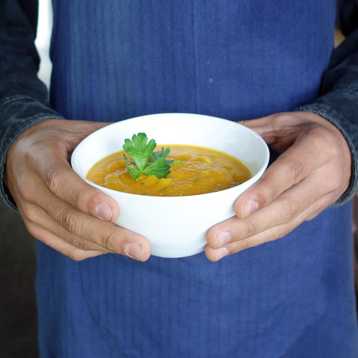bol en porcelaine de forme irrégulière rempli de soupe et tenu en main - tsé tsé
