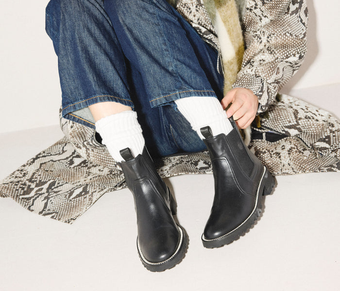 Black Bonnie rain-resistant boot by Freda Salvador featuring a sleek leather design and sturdy sole.