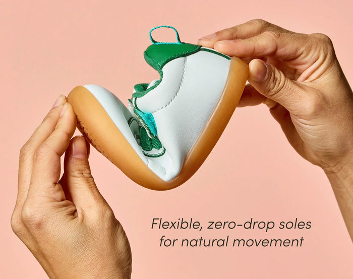Side view of person flexing Ten Little Centre Court Sneakers featuring flexible, zero-drop soles for natural movement. Available at www.tenlittle.com