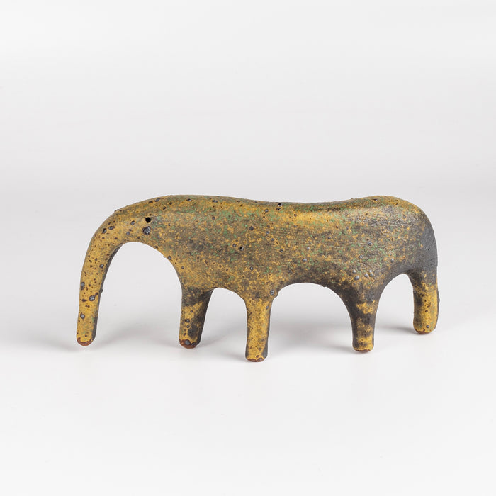 A yellow ceramic creature is ofrmed from solid clay and refined by hand, this "one of a kind" ceramic creature is made out of stoneware and glazed before getting reduction fired. Made by Carol Horst in Los Angeles.