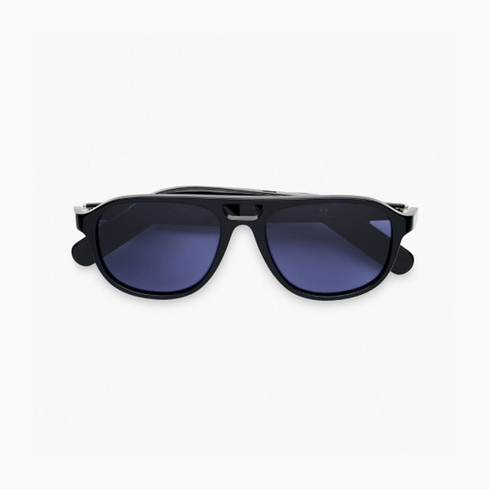 The Nautica Commander Bluetooth sunglasses feature thick black frames, dark blue lenses, and a modern curved design, combining sleek style with wireless convenience—shown against a plain white background.