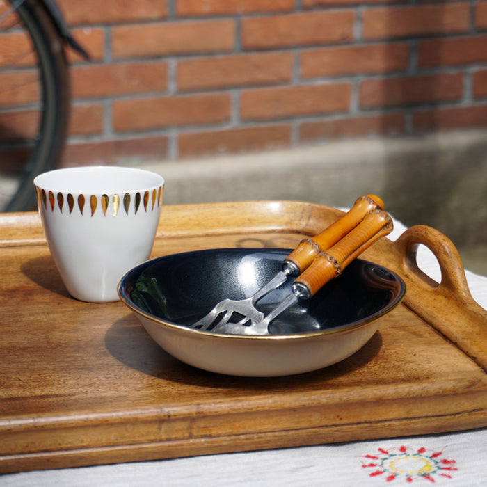 Plateau en bois avec coupelle noire et or, et tasse blanche avec des petites flammes dorées