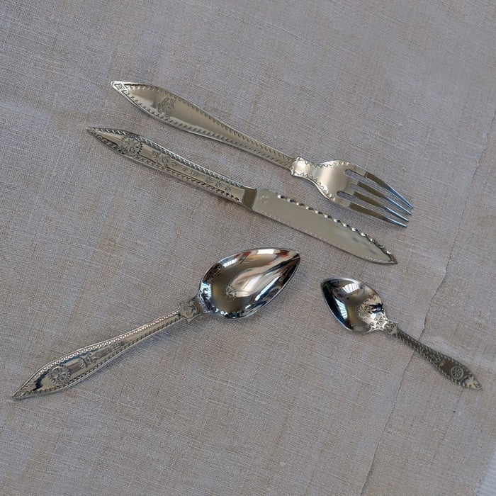 set de couverts de table en acier inoxydable avec manche poinçonné posés sur une nappe blanche - tsé tsé