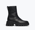 Black woven Chelsea boot by Freda Salvador featuring a sleek silhouette and elastic side panels, front view.