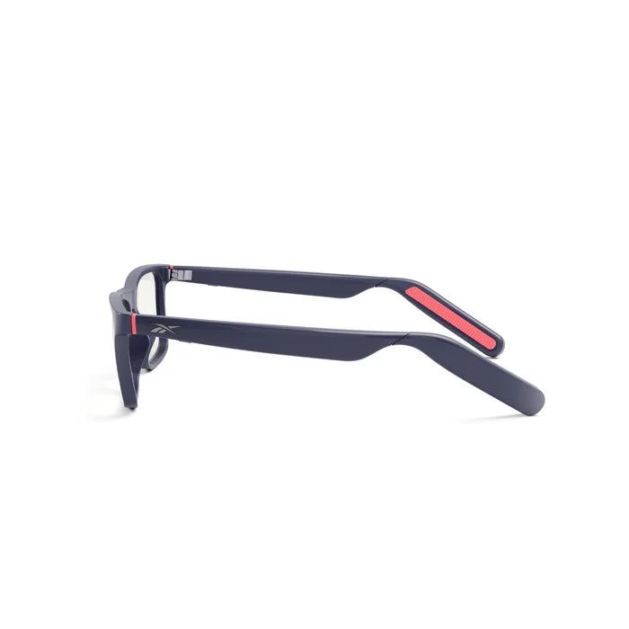 The Reebok Dash is a pair of black rectangular smart glasses with thick frames, red accents inside the arms, and a small logo on the temple, viewed from the side against a plain white background.