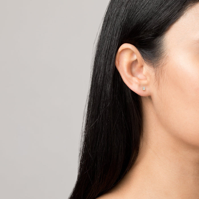 Model Close-up profile of a woman wearing a small diamond baguette stud earring