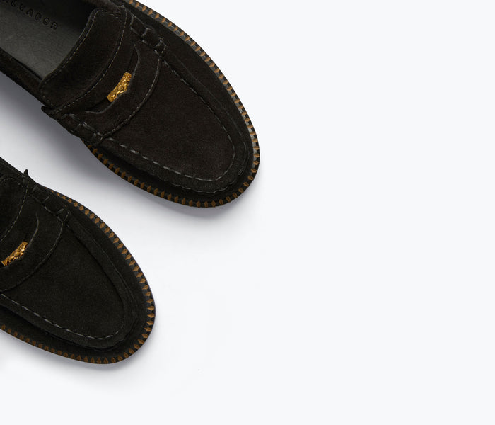 Freda Salvador Elba Penny Loafer in black suede showing classic slip-on style with sleek design and detailed stitching.
