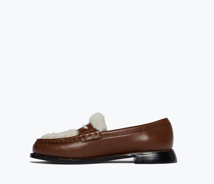 Freda Salvador Elba Penny Loafer in cognac leather with sherling lining, showing the stylish slip-on design and detailed stitching.