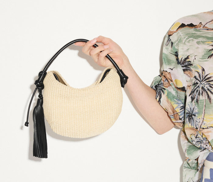Freda Salvador Elis Mini Crescent Bag made of natural raffia with a compact, curved design and subtle brand details.