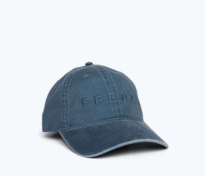Blue embroidered Freda hat by OTTO, casual apparel accessory with detailed stitching, shown from the side view.
