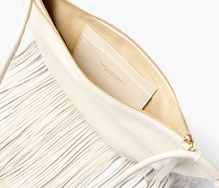 Freda Salvador Erika Crescent Fringe Bag in bone calf leather, showing the inside view with spacious interior and elegant fringe details.