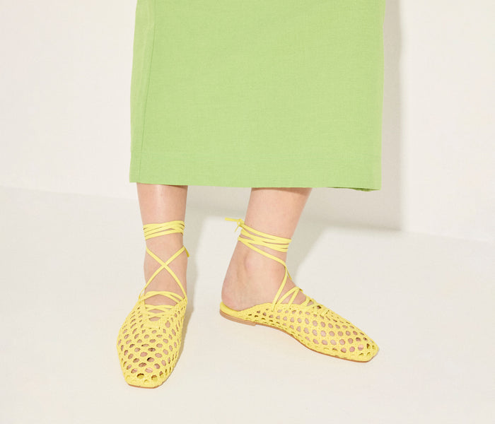 Yellow woven ankle lace-up flat mule by Freda Salvador, featuring a stylish woven design and sleek silhouette.