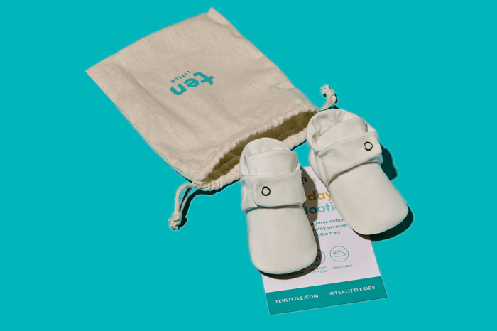 Front view of Ten Little Everyday Baby Booties with dust bag - Soft White. Available at www.tenlittle.com