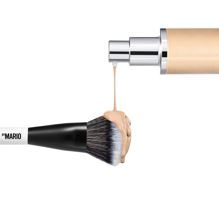 A image of foundation dripping onto the larger side of the Makeup By Mario's F4 Dual-Ended Foundation and face brush.