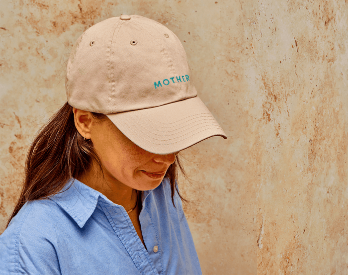 Adult wearing Ten Little Mother Hat. Available from www.tenlittle.com