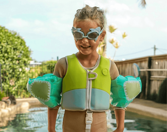 Child by the pool wearing Sunnylife Shark Float Vest. Available from www.tenlittle.com