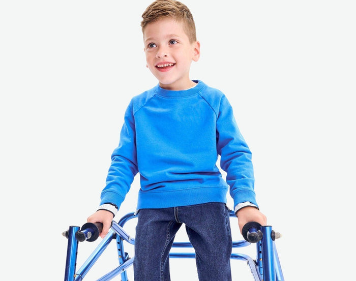 Boy standing with walker wearing Primary - French Terry Sweatshirt - Blueberry - available at www.tenlittle.com