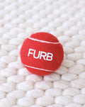 Bright red dog tennis ball for active play and fetch games.