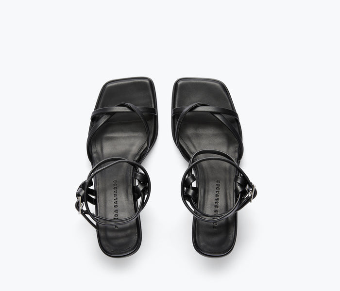 Black Gianna strappy heeled sandal by Freda Salvador shown from calf top view, showcasing the elegant heel and strap design.