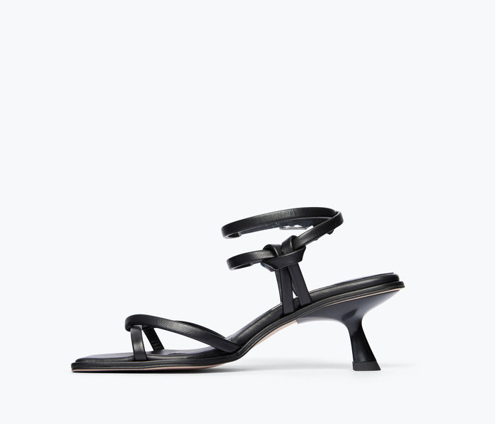Black Gianna strappy heeled sandal by Freda Salvador, showing the inside view of the calf-high strap and elegant heel.