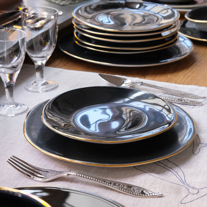 Table dréssée avec de la vaisselle irrégulière, noire et or - tsé tsé