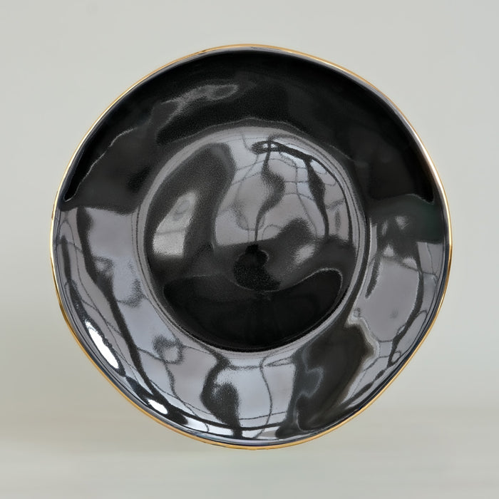 Assiette de forme irrégulière, émail noir et contour or. tsé tsé