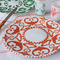 Grande assiette blanche avec motif orange, sur une table