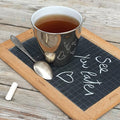 grande tasse à thé extérieur platine effet miroir posée sur une ardoise d'écolier - tsé tsé