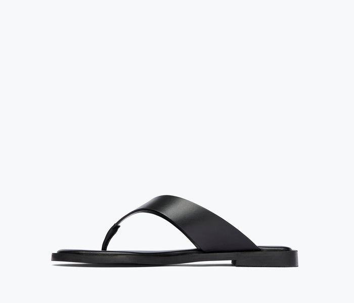 Black leather Halle thong sandal by Freda Salvador, shown from inside angle highlighting the sleek design and leather straps.