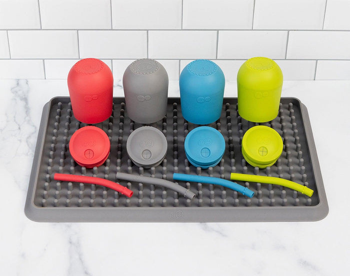 ezpz Happy Cup & Straw in blue and 3 other colors sitting on ezpz Drying Rack. Available at tenlittle.com
