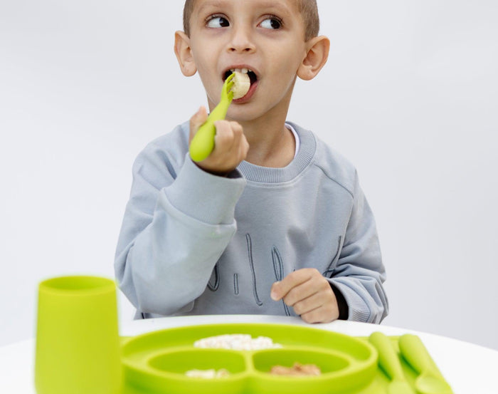 Child Eating Using Ezpz Happy Utensils Set of 3 in Lime - Available in www.tenlittle.com