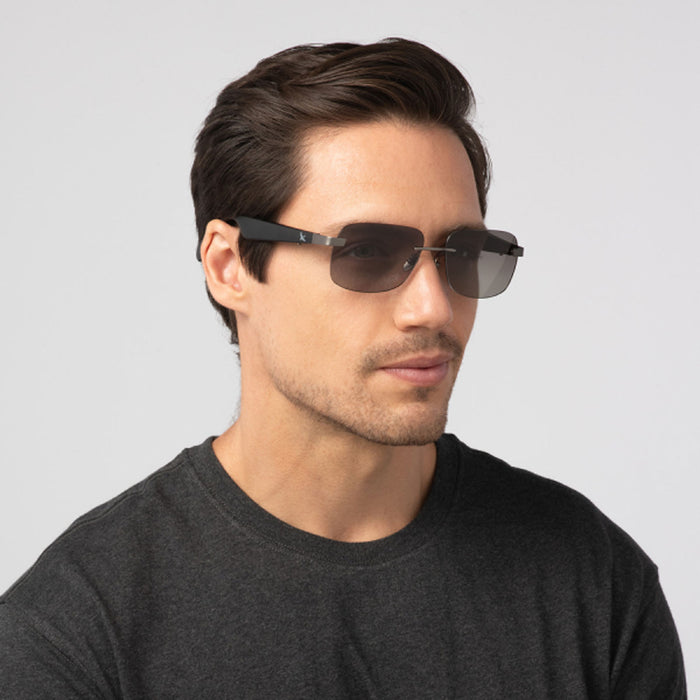 A man with short brown hair wears Eddie Bauer Horizon UV400 polarized sunglasses and a dark grey t-shirt, gazing slightly to the side against a plain light background.