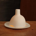 bougie allumée dans un photophore blanc en porcelaine mate - tsé tsé