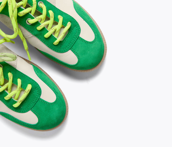 FREDA SALVADOR Jackie Court sneaker in green suede with detailed stitching and sleek design, close-up view.