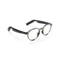 Reebok Jet round smart eyewear features black temple arms and slightly tinted lenses for a sleek look, with open-ear audio functionality. Displayed on a white background.