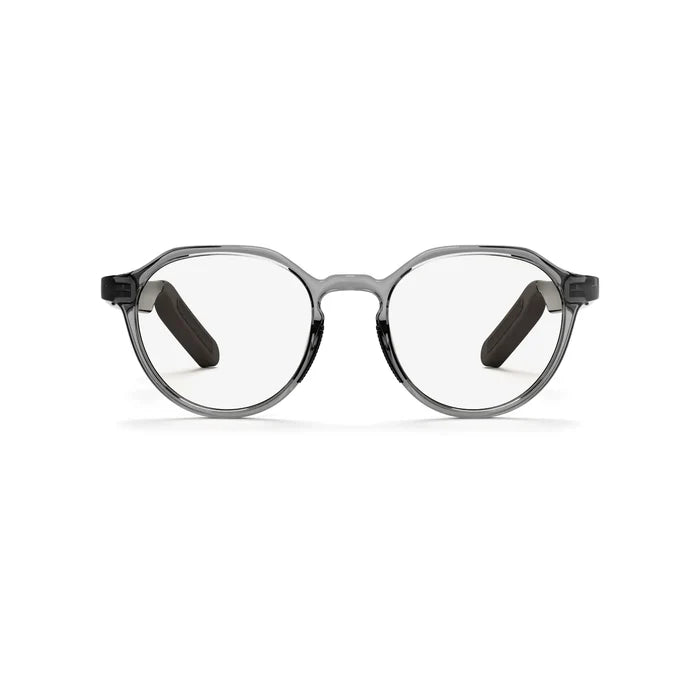 The Reebok Jet features round clear lenses and transparent gray frames with black temples, giving these premium smart glasses a modern look. The glasses are displayed on a plain white background.