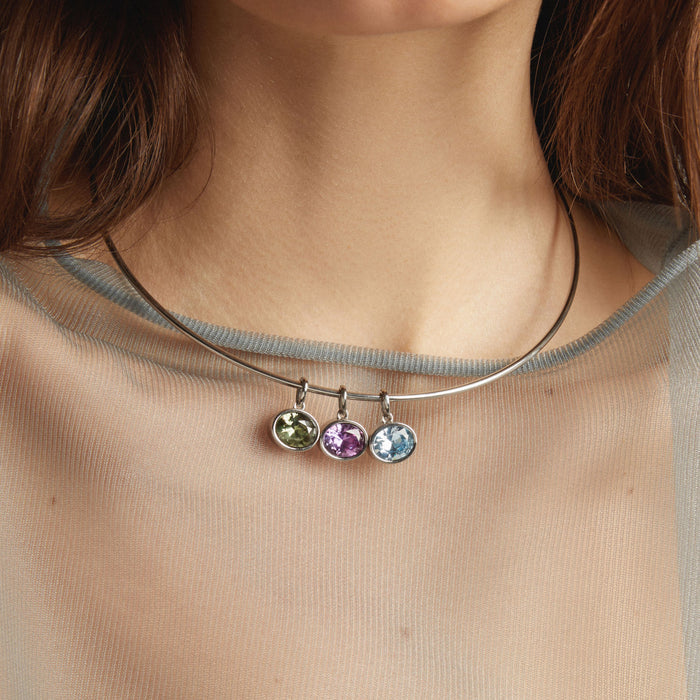Model. Necklace with three colorful gemstones worn by a person