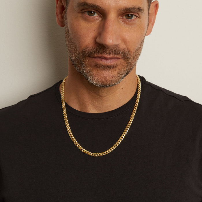 Model. Man in black shirt wearing gold chain necklace